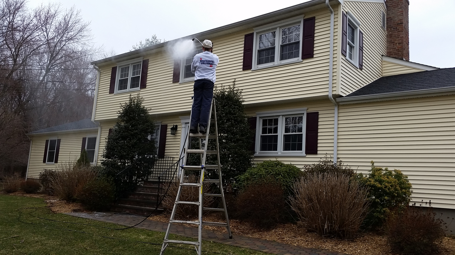 The Powerwash Guys crew soft-washing a colonial home